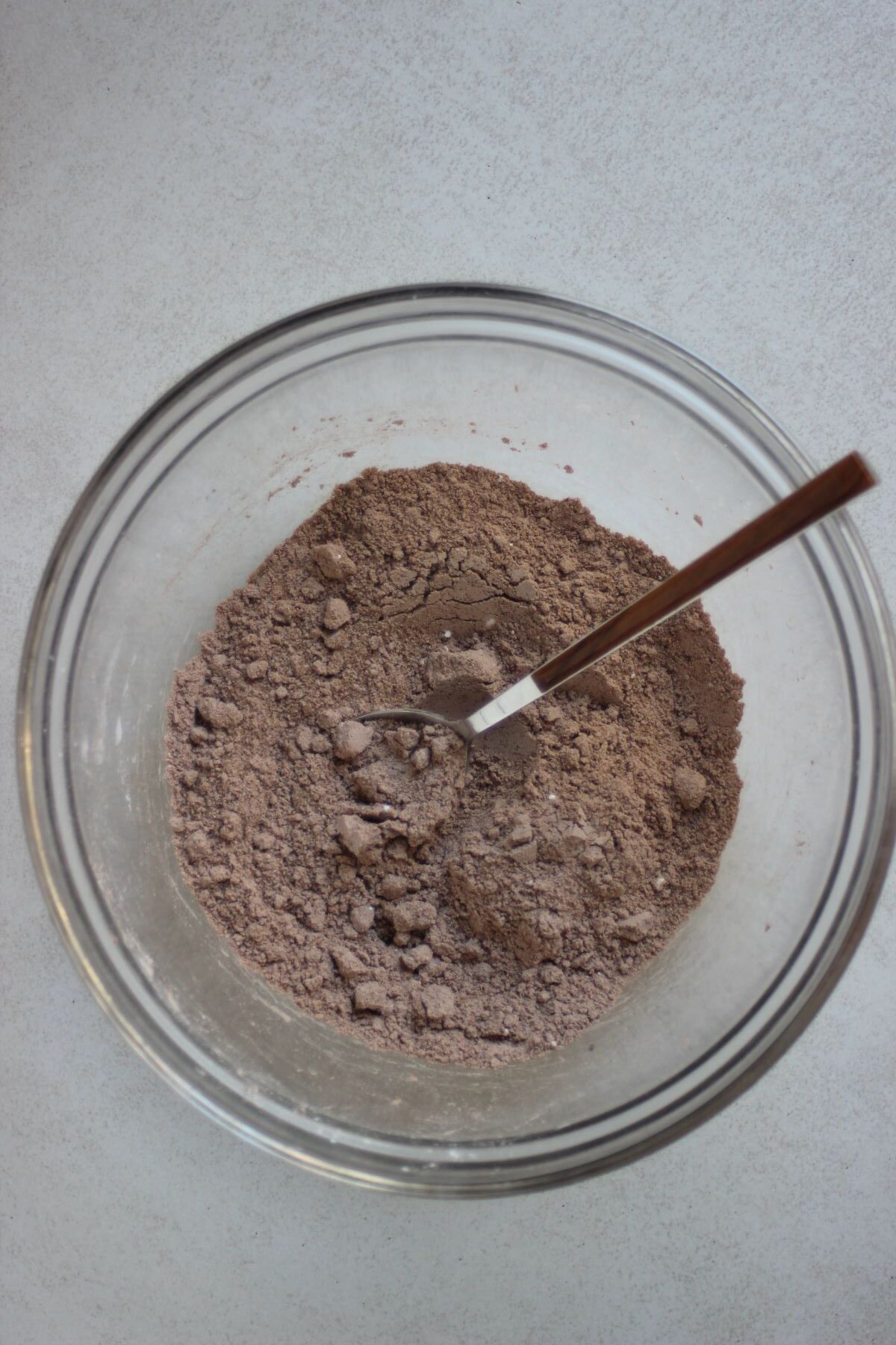 Glass bowl with a mix of flours and a  spoon.