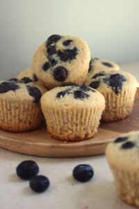 Blueberry muffins on a wooden plate.