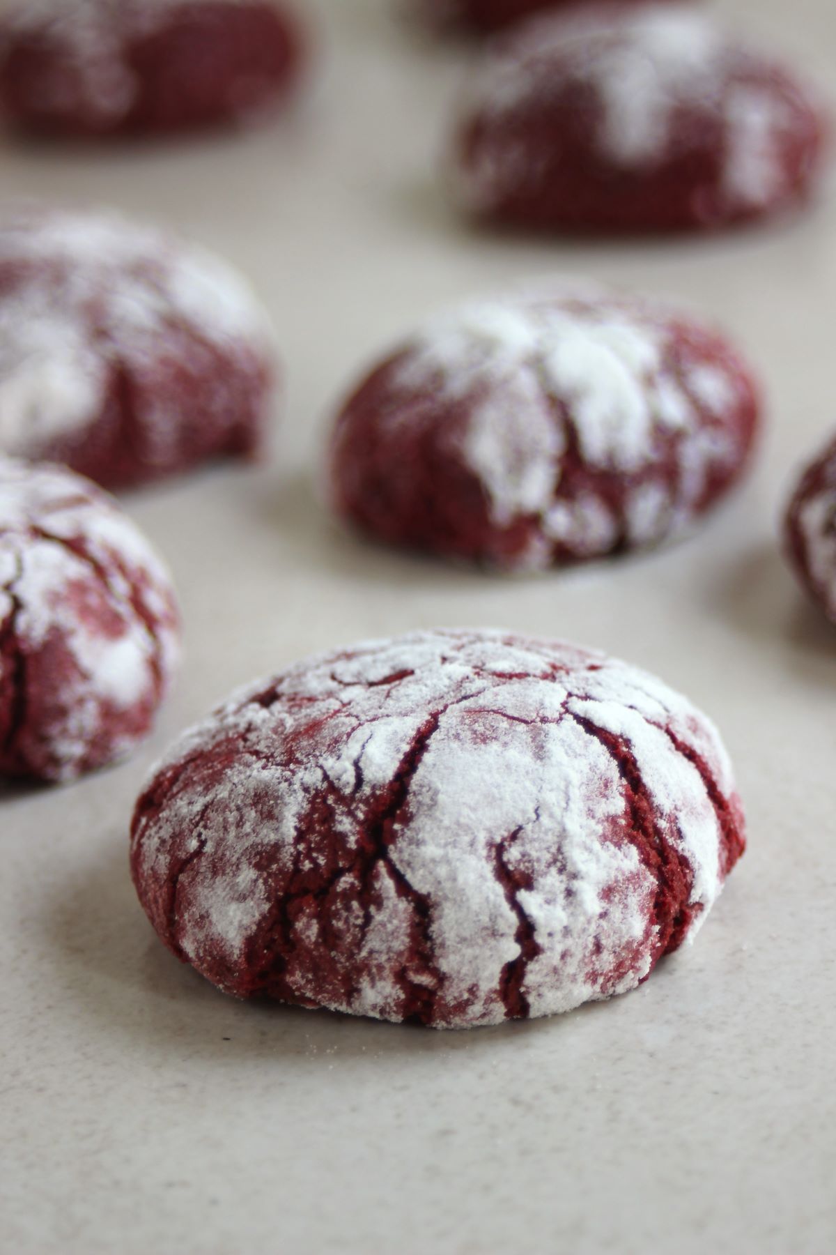 Red velvet crinkle cookies on a white surface.