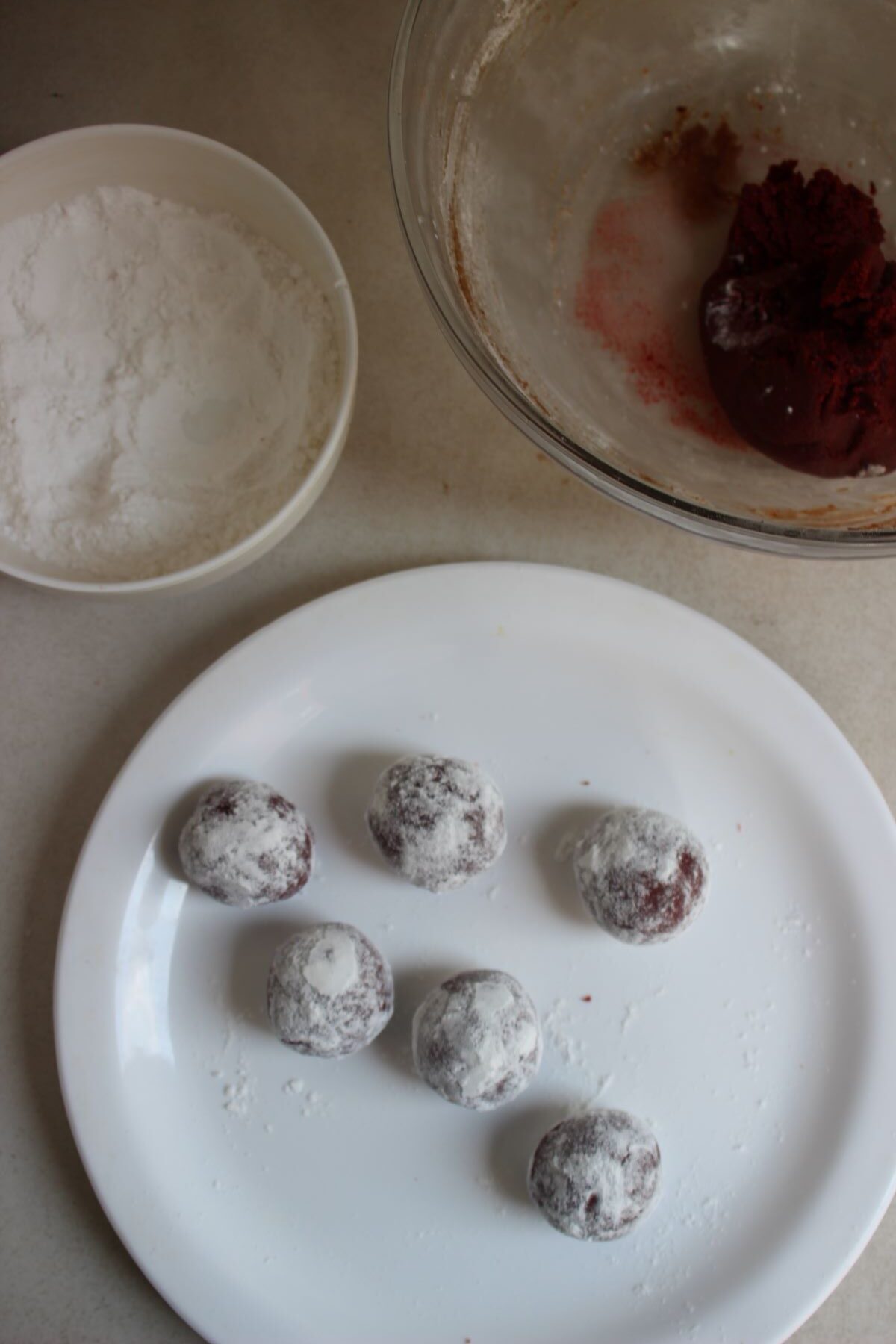 Plate with balls of dough covered with powdered sugar, Mini bowl with powdered sugar.