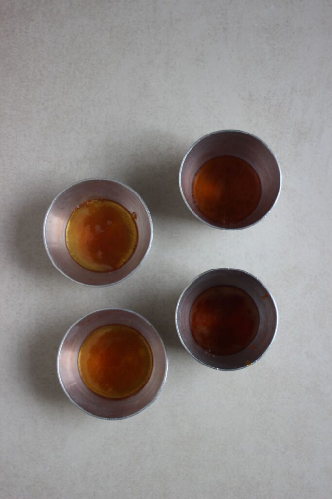 Four flan molds with caramel.