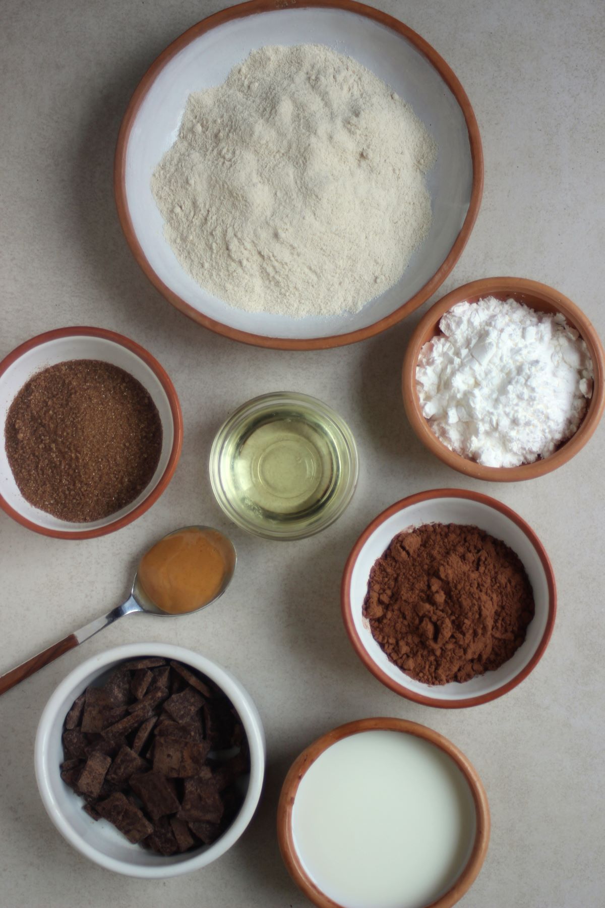 Vegan chocolate cookie ingredients on different plates seen from above.