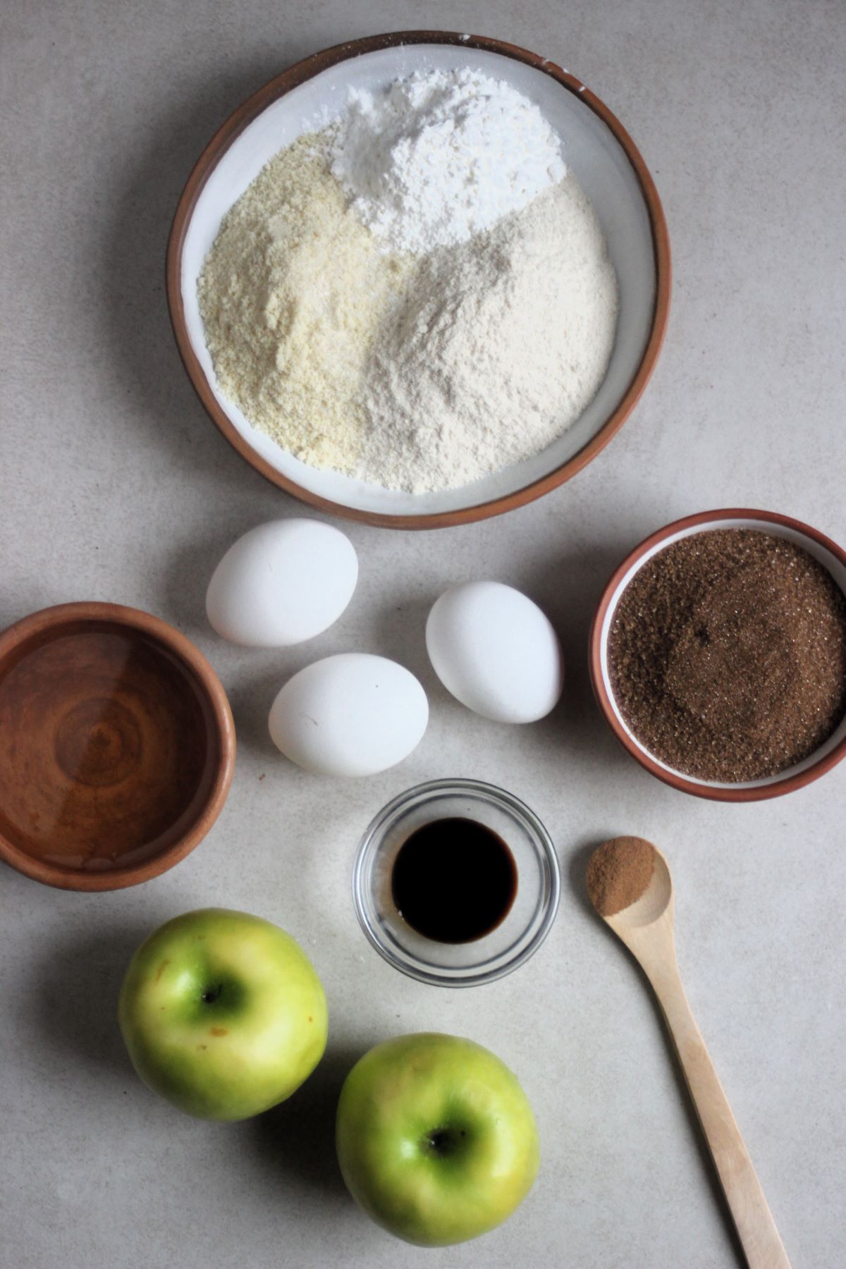 The apple cake recipe ingredients in different plates seen from above.