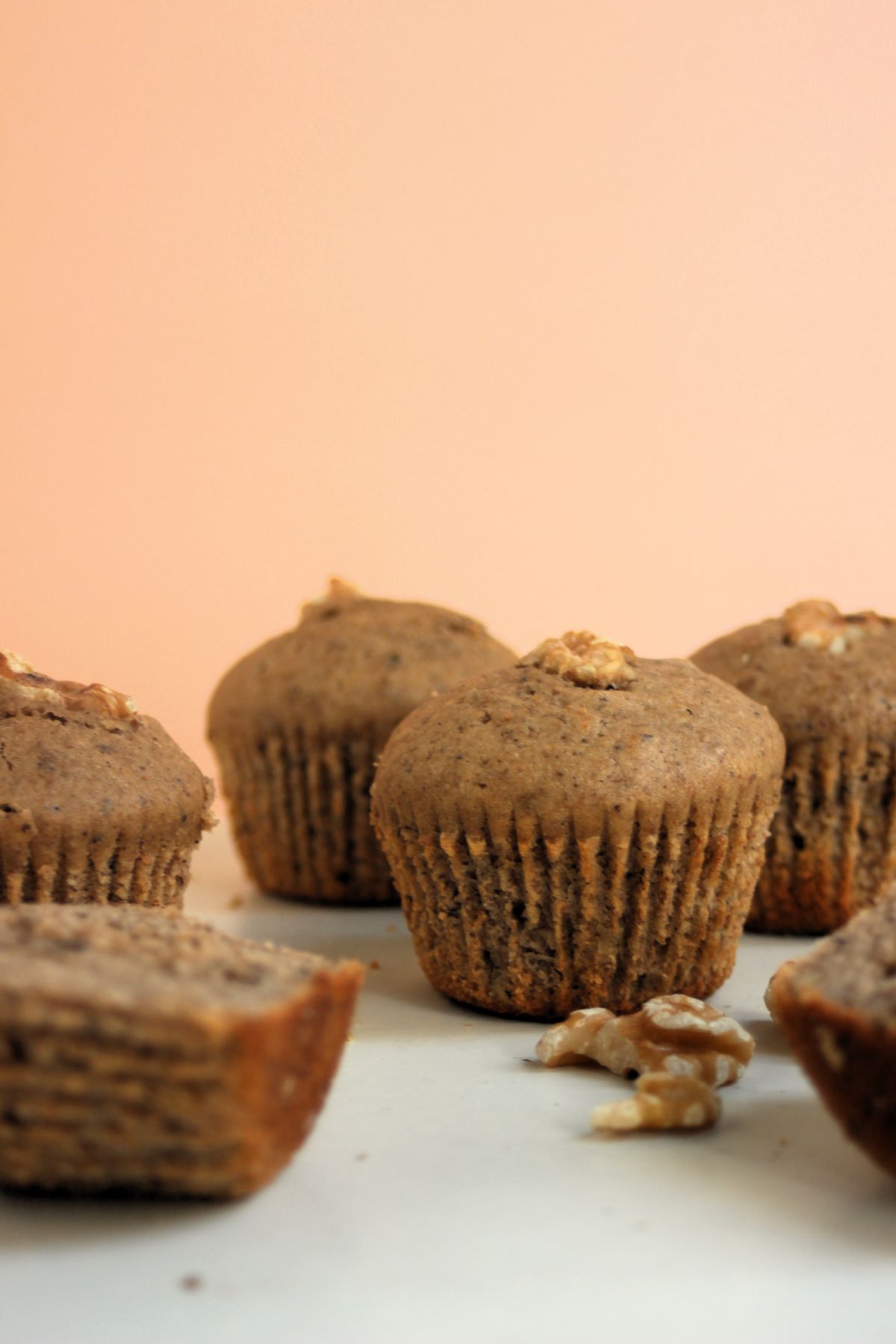 Banana muffins on a white surface, nuts around.