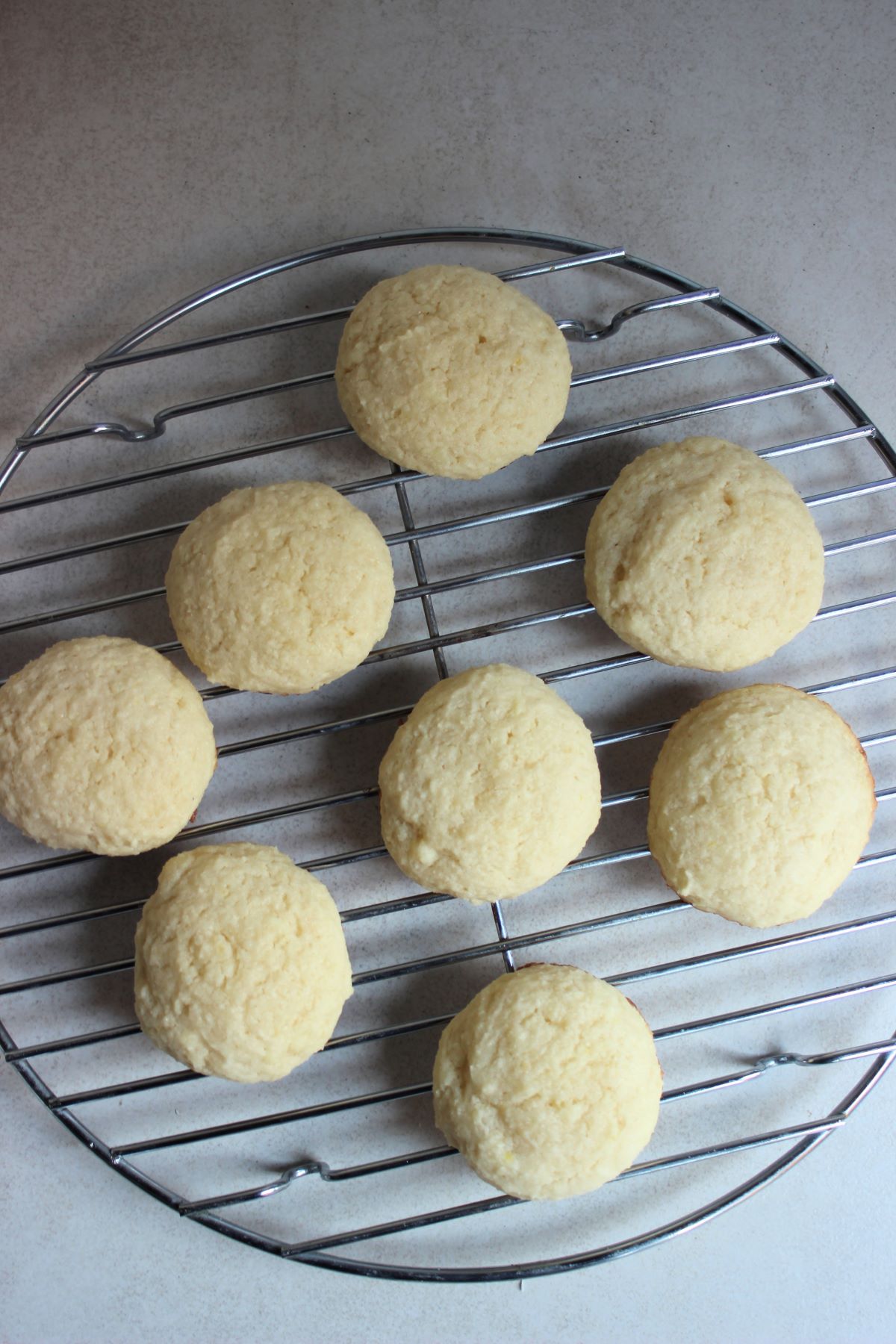 Ricotta cookies on a round wire rack.