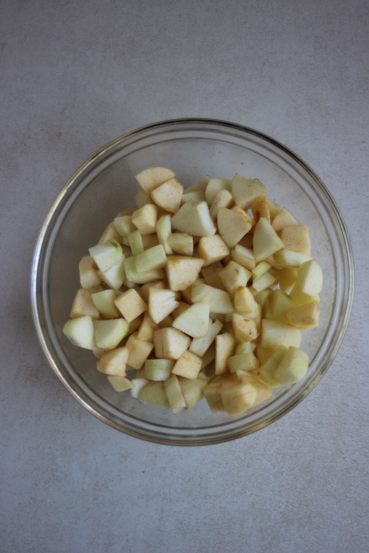 Glass bowl with diced and peeled apples.