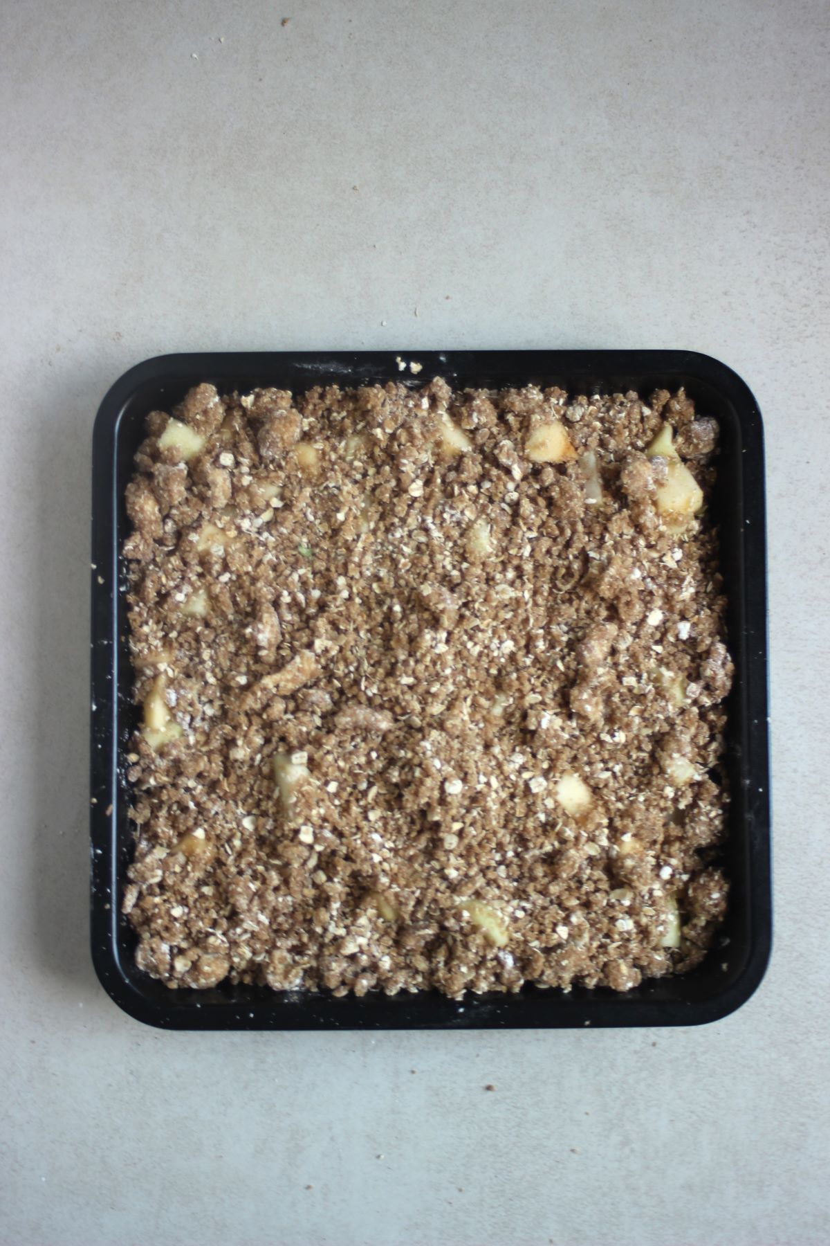Baking dish with apple crisp before baked seen from above.