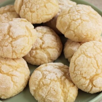 Lemon crinkle cookies on a light aqua plate.