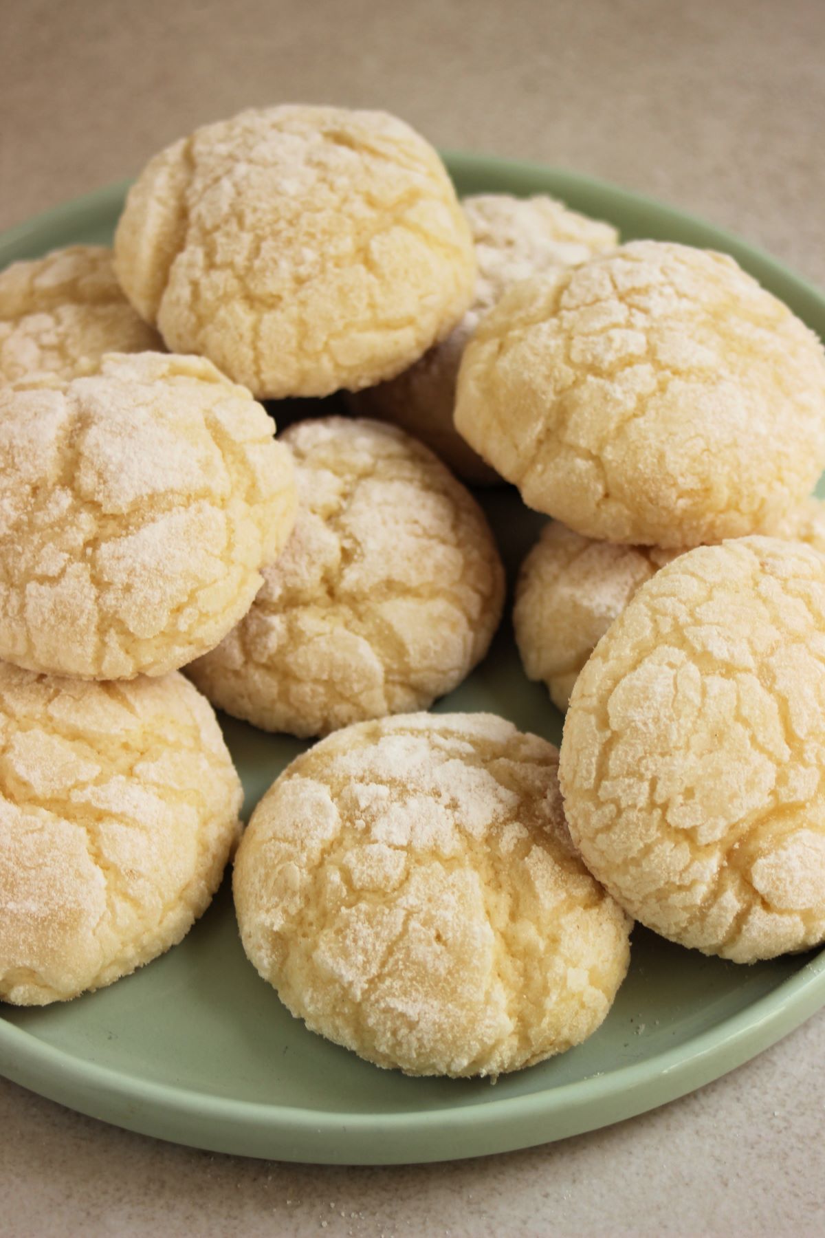 Lemon crinkle cookies on a light aqua plate.