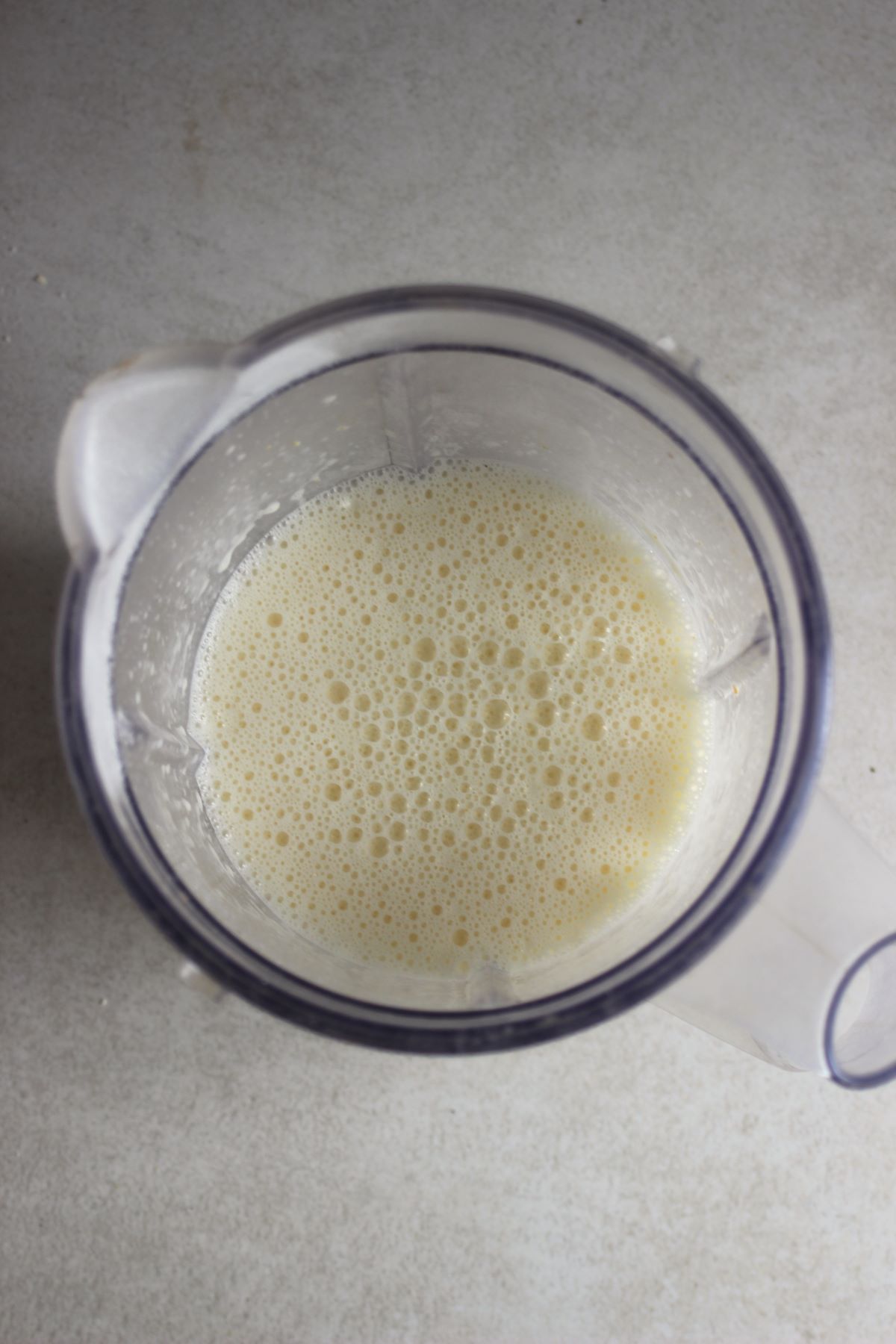 A blender with a white liquid seen from above.