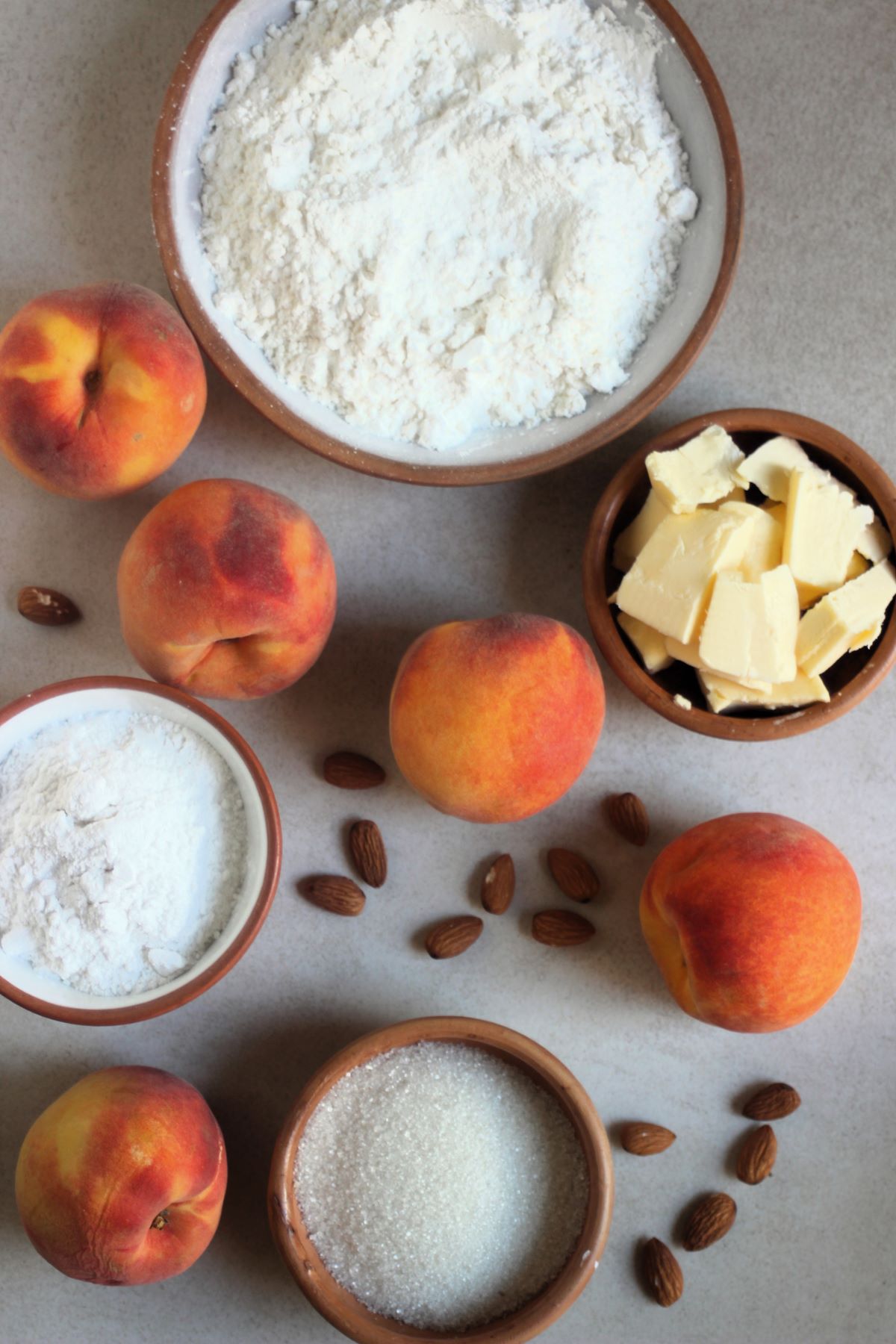 Peach galette ingredients on a white surface seen from above.