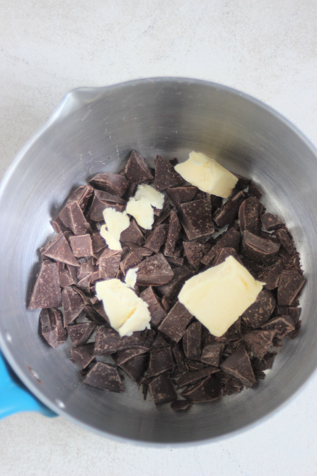 Chopped chocolate and pieces of butter in a deep saucepan.