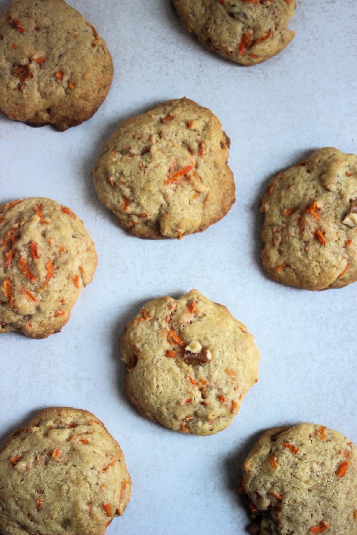 Carrot cake cookies on a white surface seen from above.