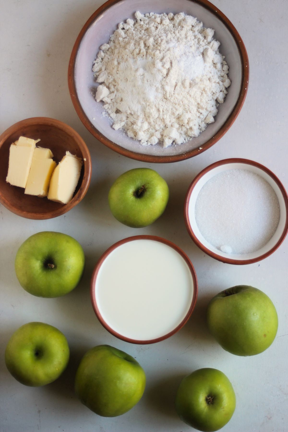 Apple cobbler ingredients on a white surface seen from above.