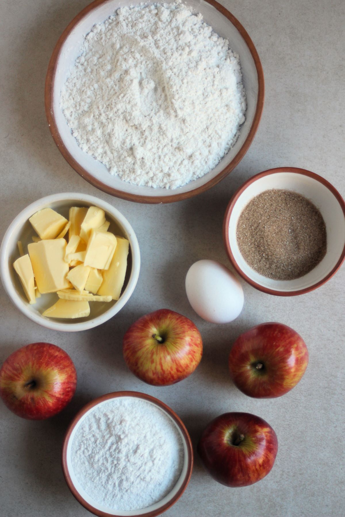 Apple galette ingredients on a white surface seen from above.