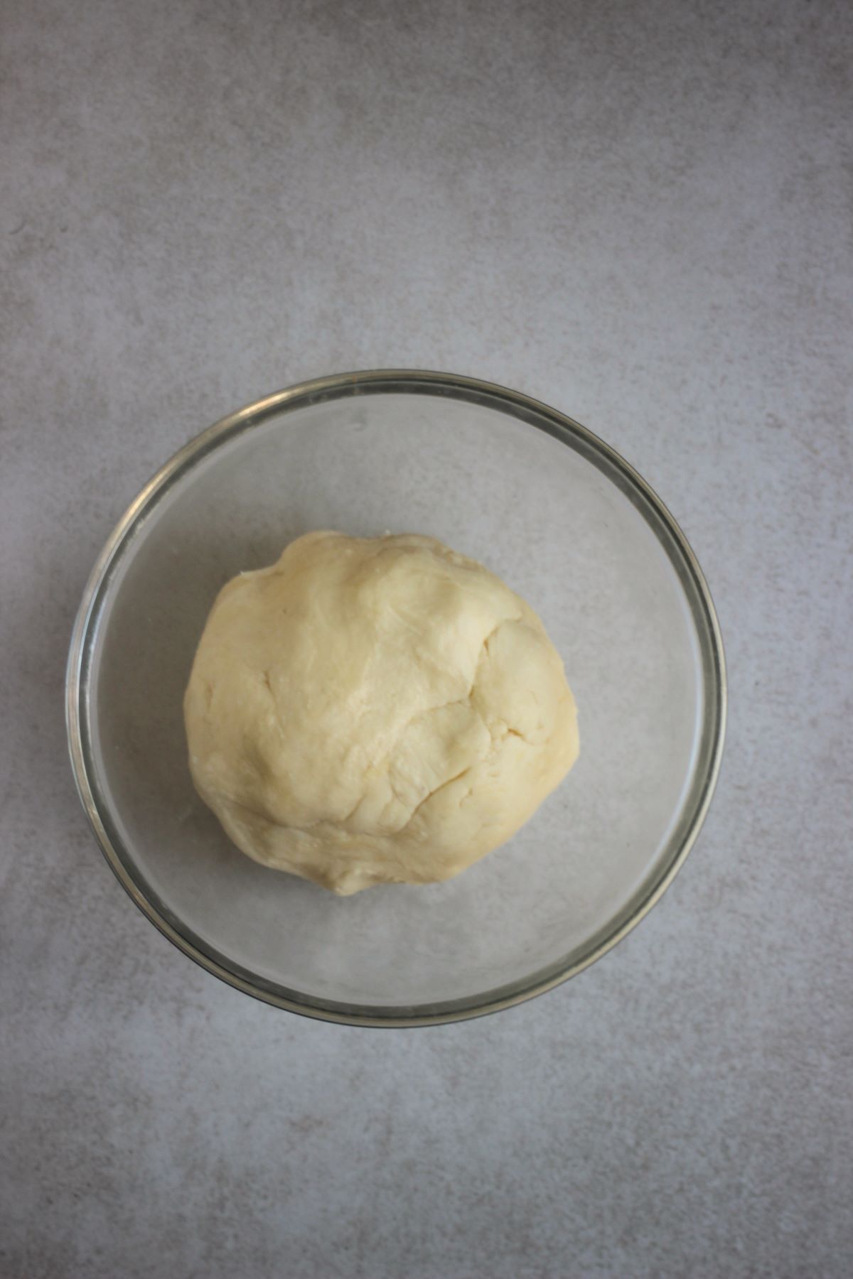 Glass bowl with a dough ball.