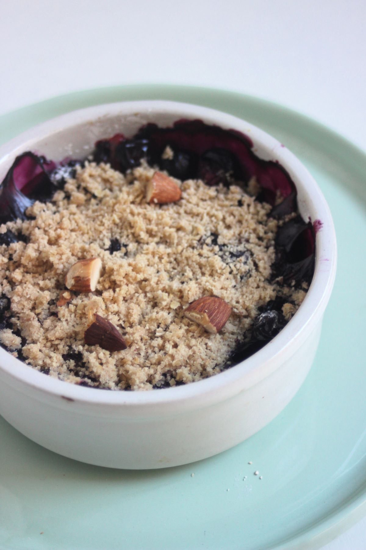 Blueberry crisp on an aqua green plate.