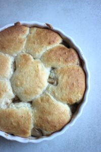 Apple cobbler on a round baking pan seen from above.