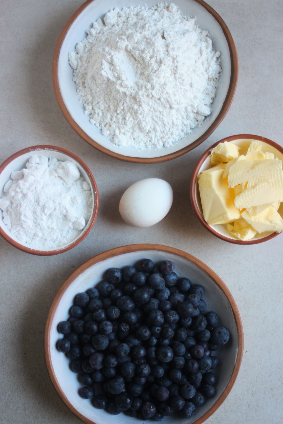 Blueberry galette ingredients on a white surface seen from above.