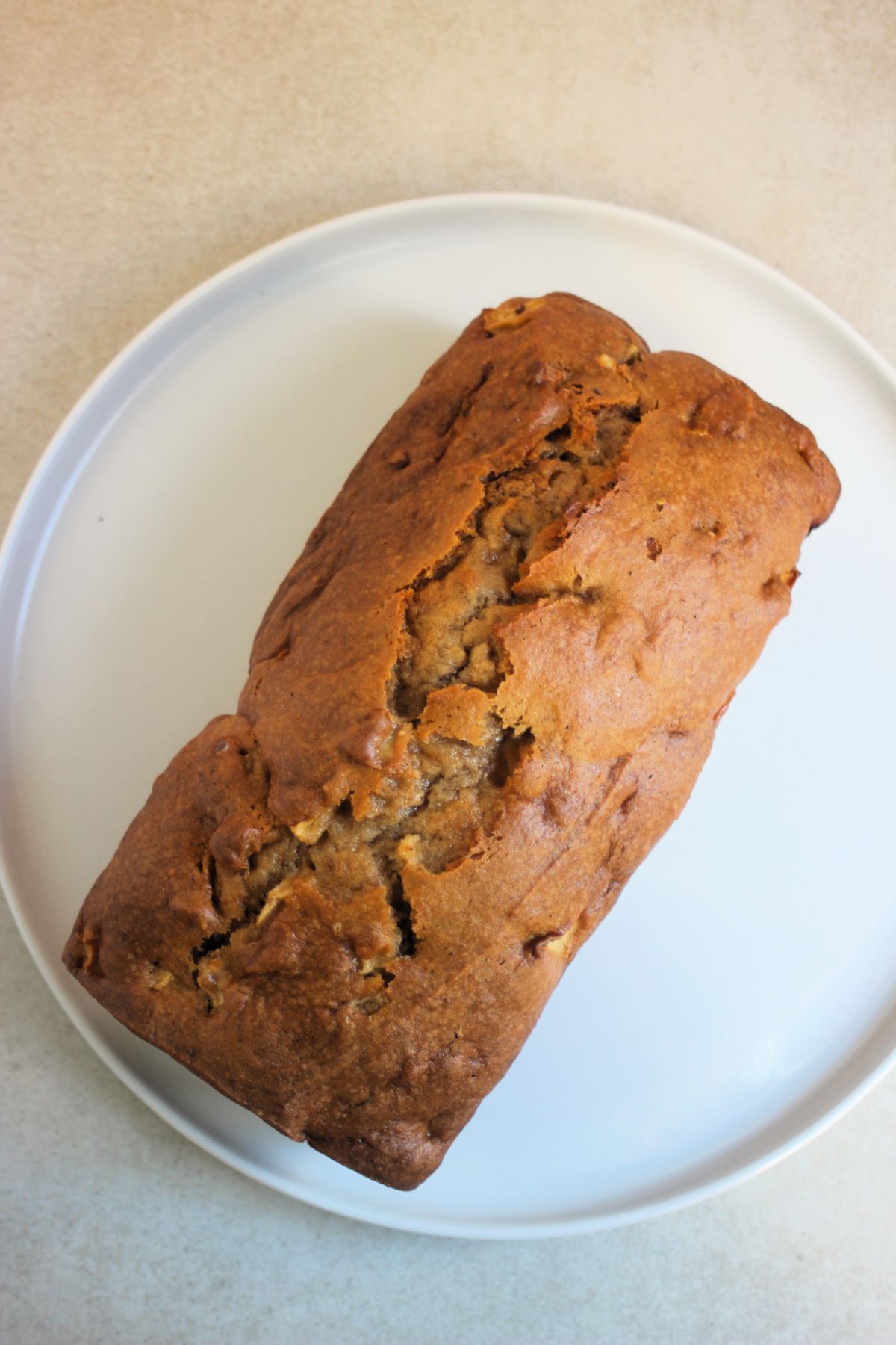 Apple bread on a white plate seen from above.