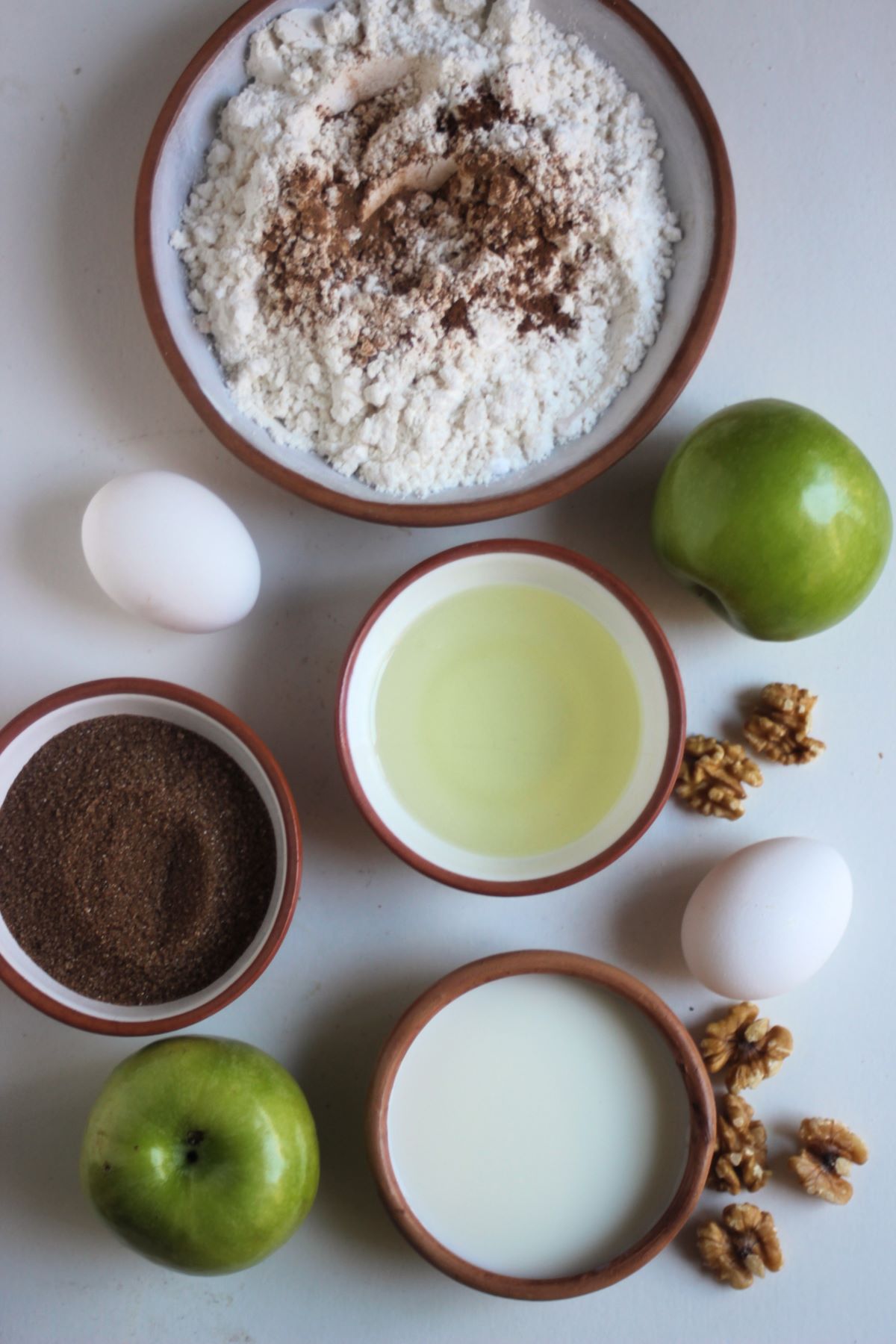 Apple bread ingredients on a white surface seen from above.