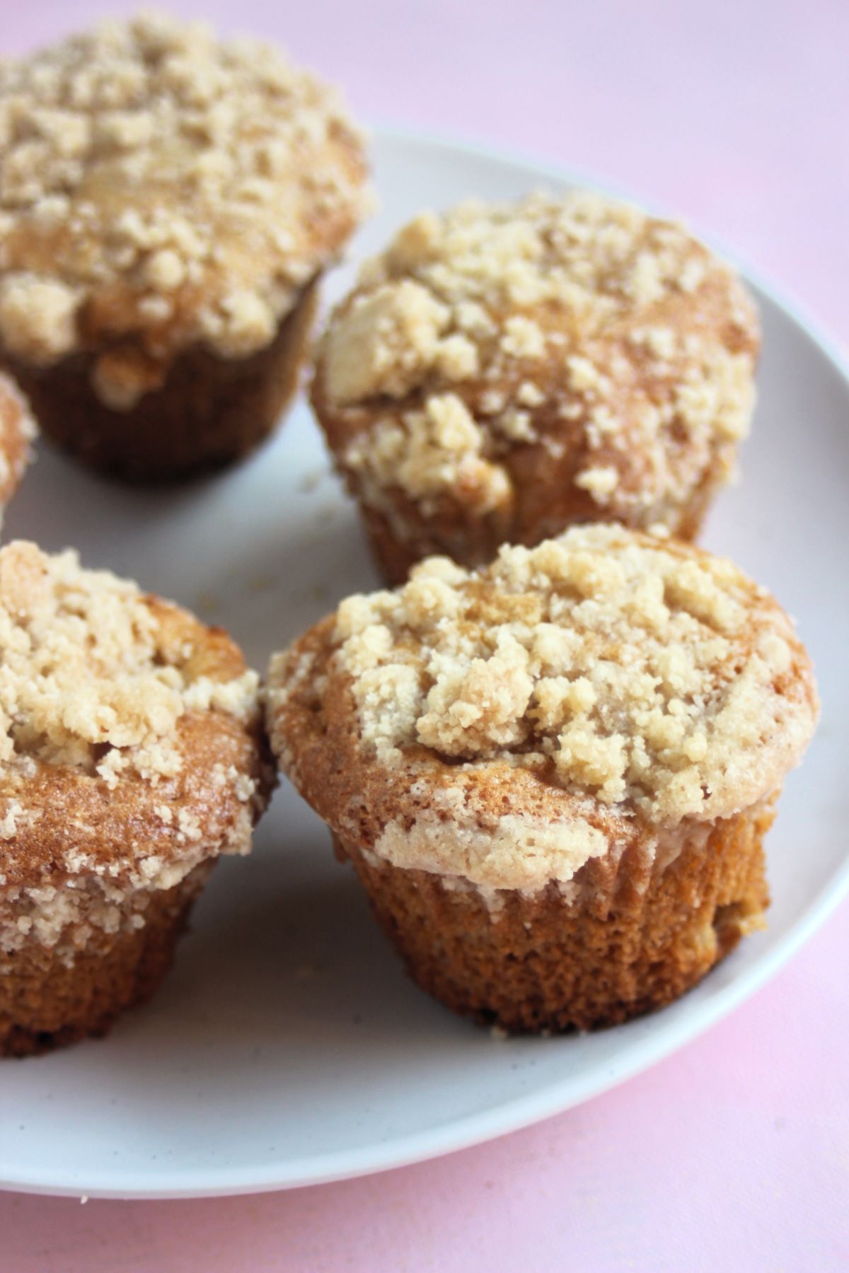 Apple crumb muffins on a white plate.