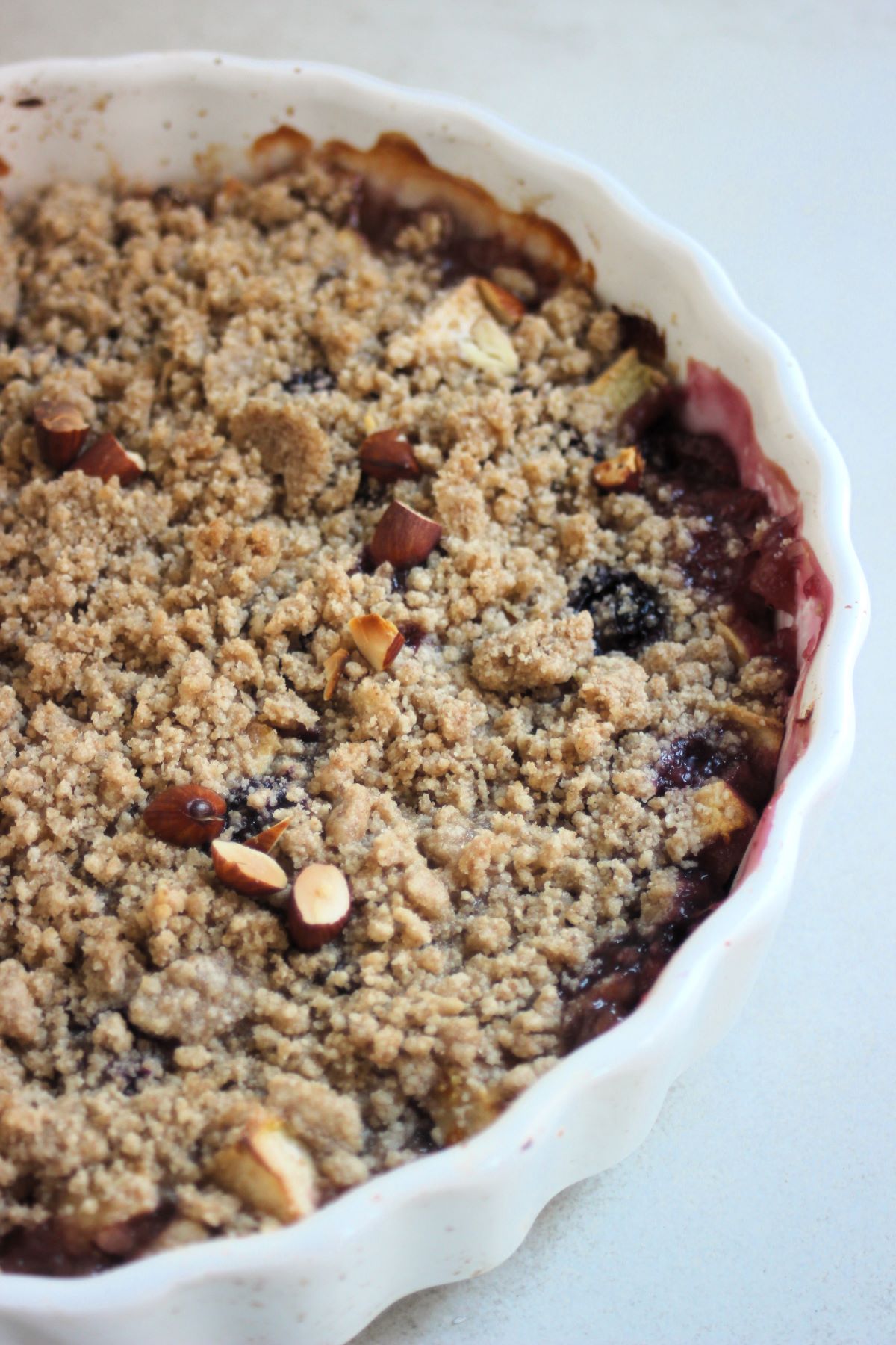 Apple crumble in a round white baking dish.