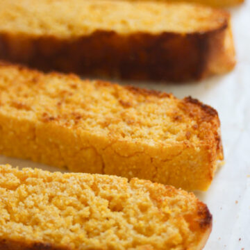 Slices of corn bread on a white surface.