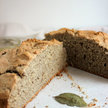 A soda bread cut into two halves on a white surface.