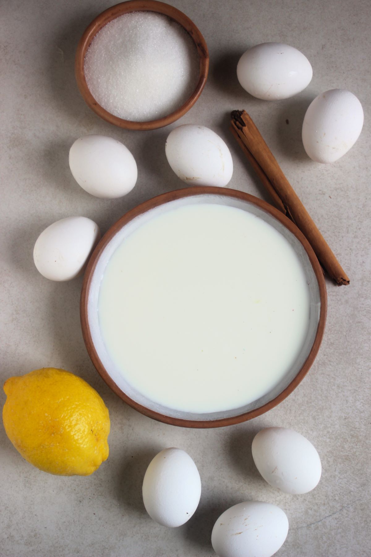 Crema catalana ingredients on a white surface seem from above.