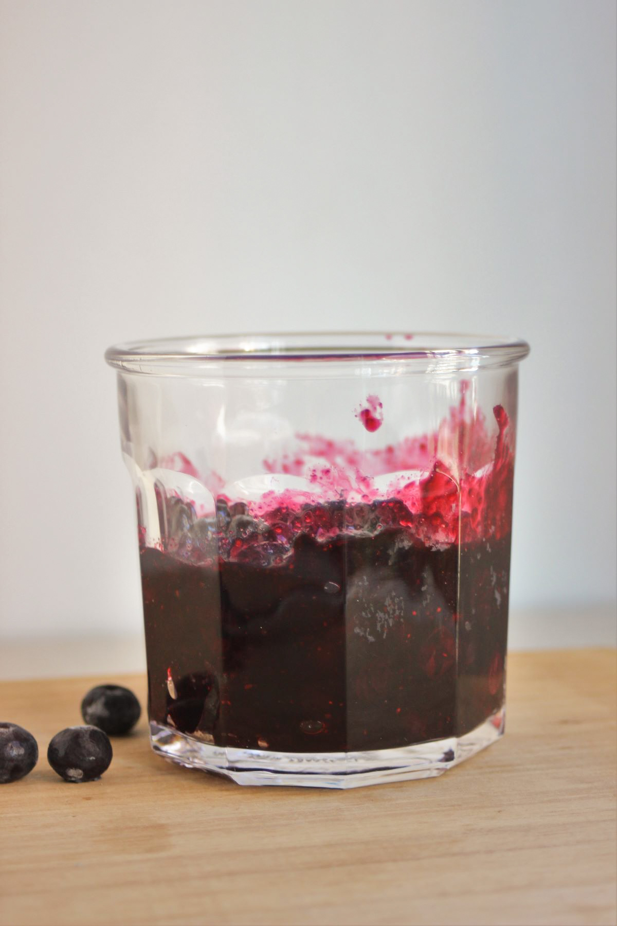 Jar with blueberry sauce. Fresh blueberries on the side.