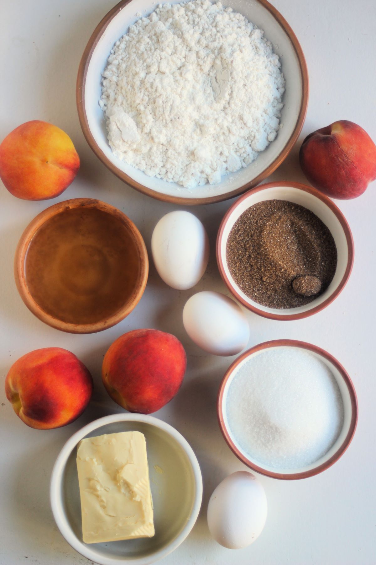 Peach upside down cake ingredients on a white surface seen from above.