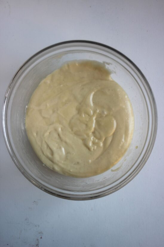Glass bowl with a cream colour mixture.