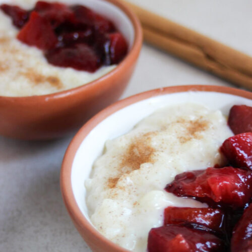 Two tiny bowls with rice pudding and plum compote.