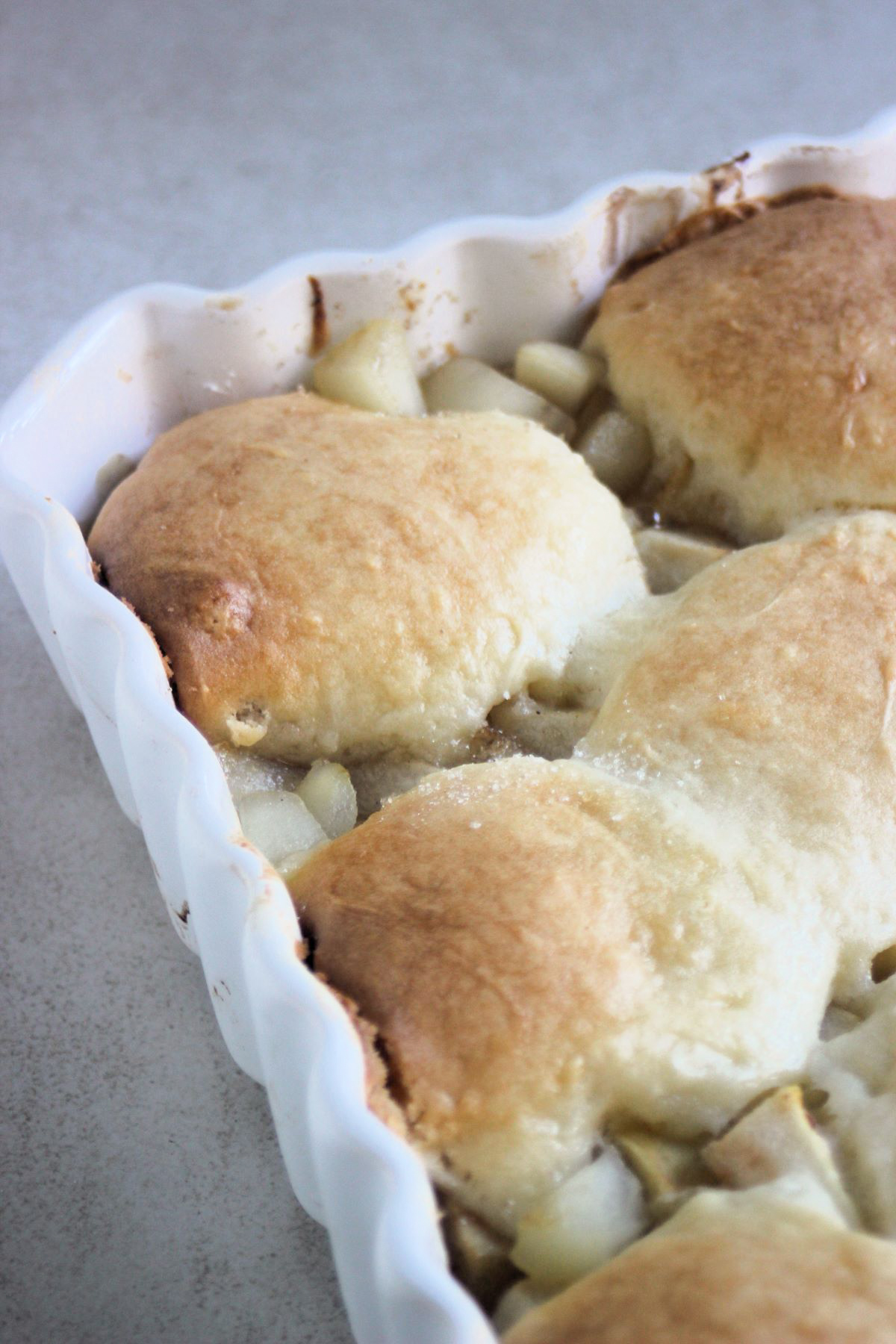 View of a corner of a rectangular baking dish with pear cobbler.