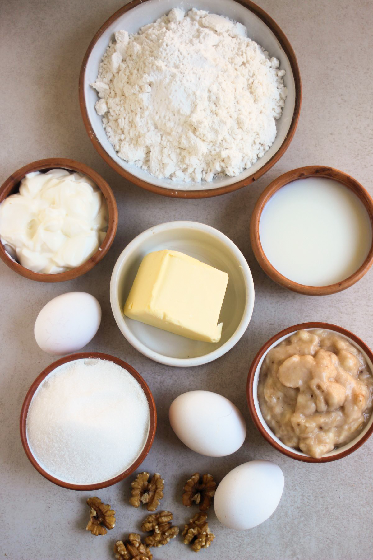 Banana bundt cake ingredients on a white surface seen from above.