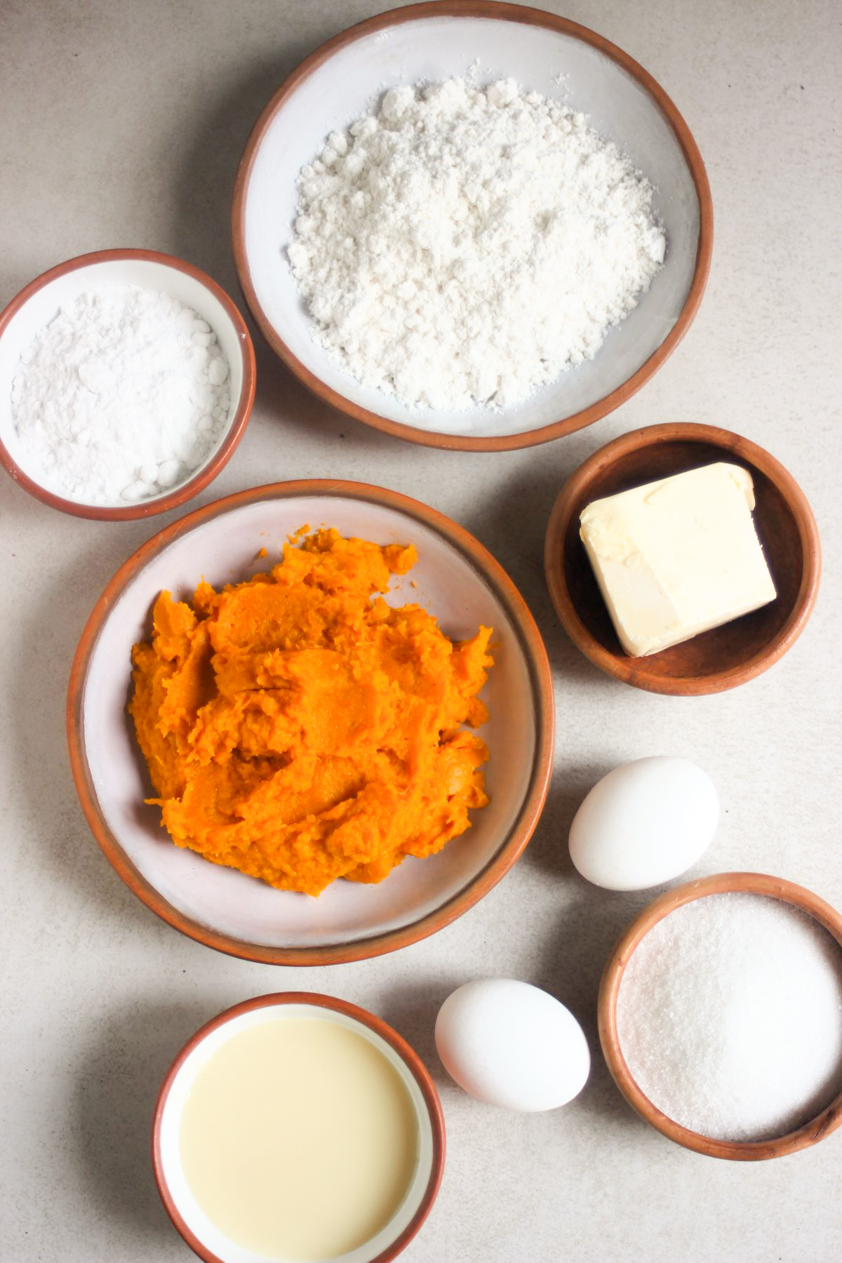Pumpkin pie ingredients on a white surface seen from above.