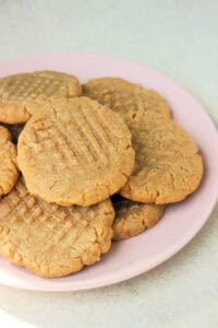 Peanut butter cookies on a pink plate seen from above.