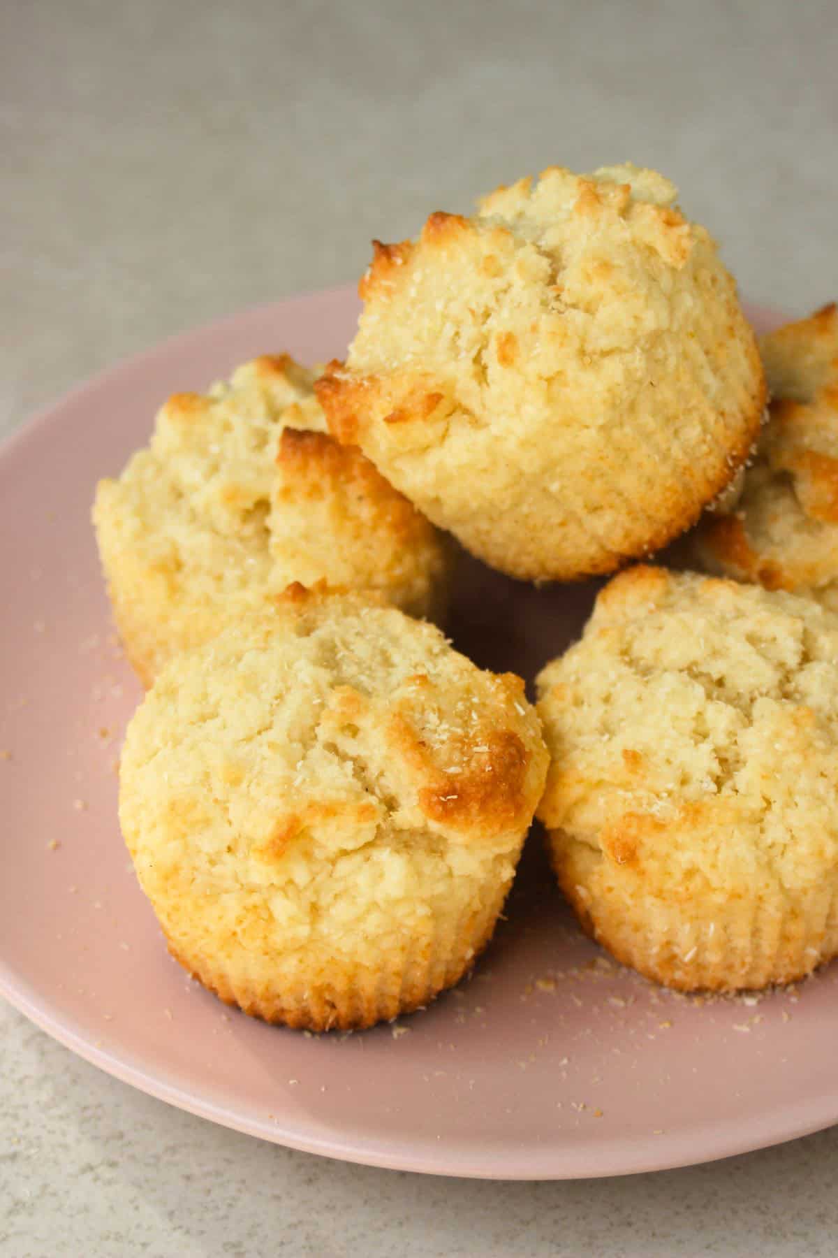 Coconut muffins on a pink plate.