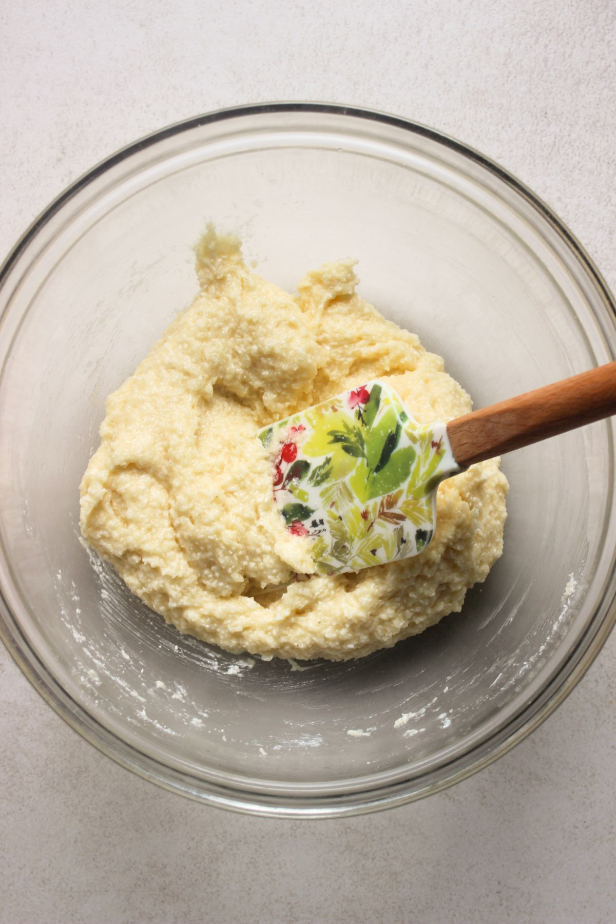 Glass bowl with a sticky mixture and a rubber spatula.