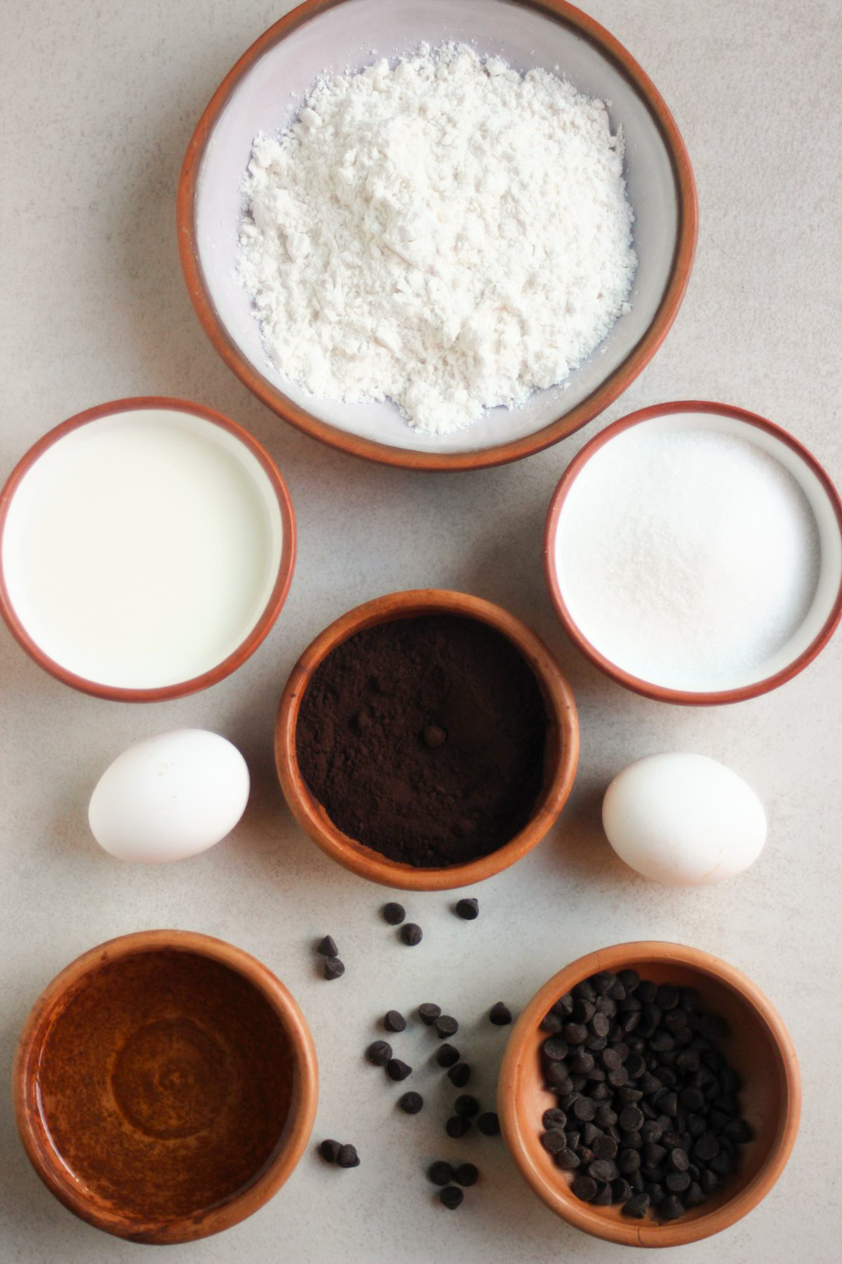 Double chocolate muffins ingredients on a white surface seen from above.