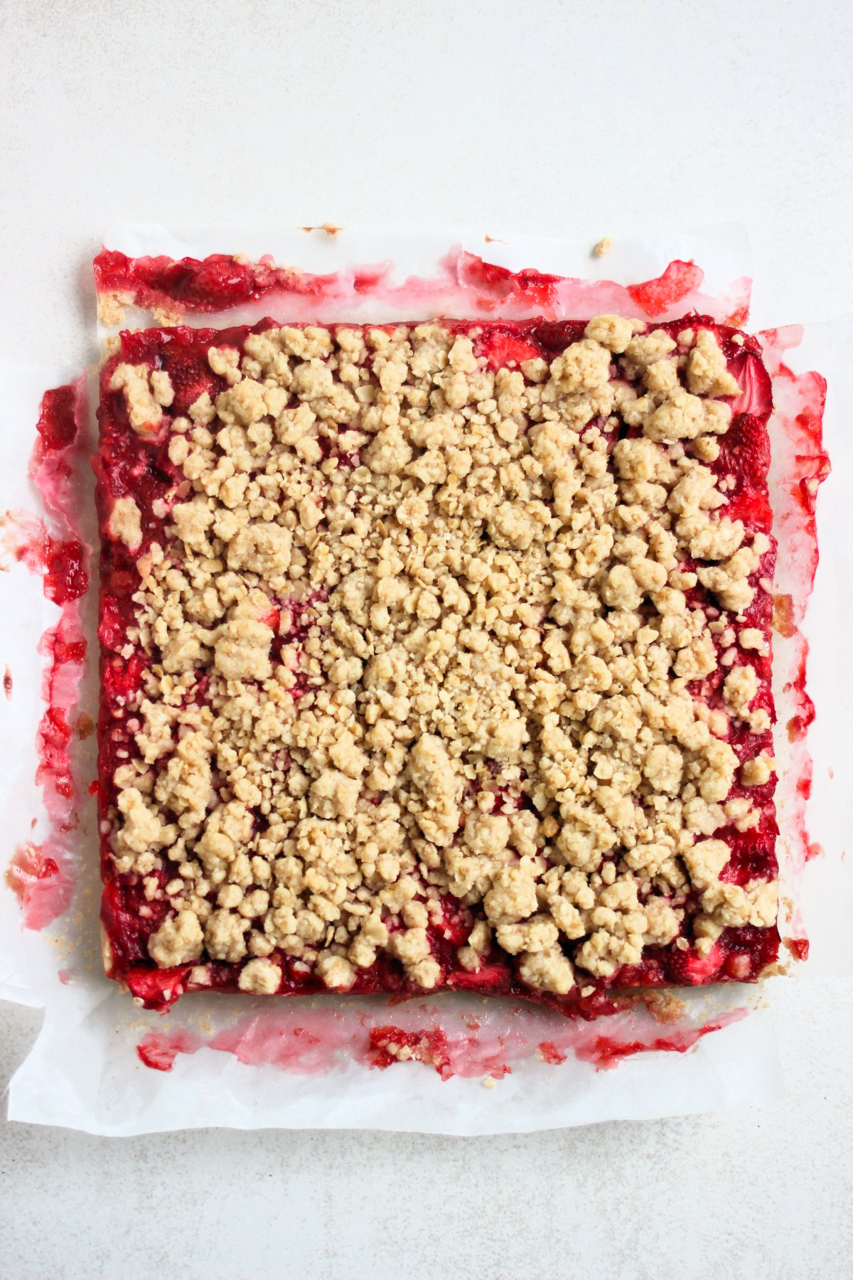 Strawberry bars on parchment paper. Top view. White background.