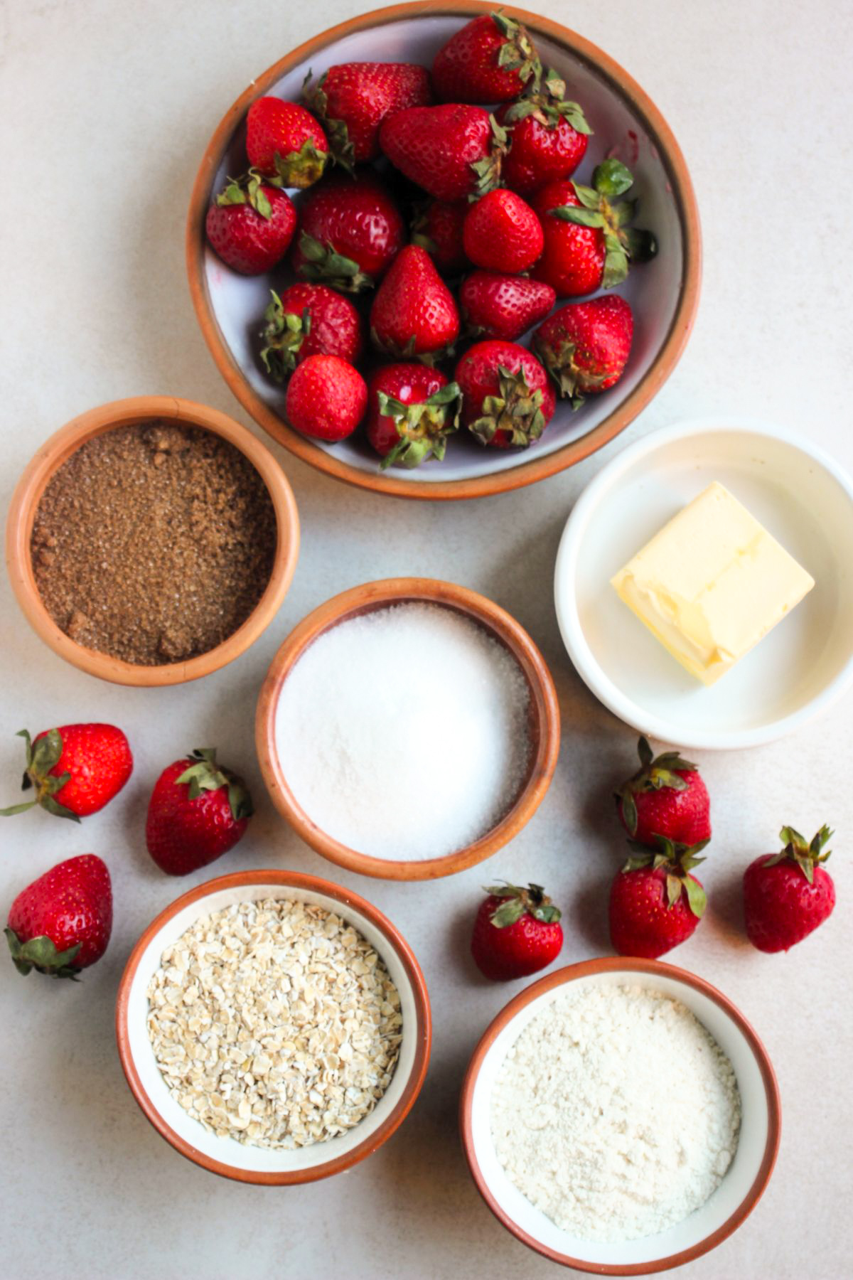 Top view of straberry crisp ingredients on a white surface.