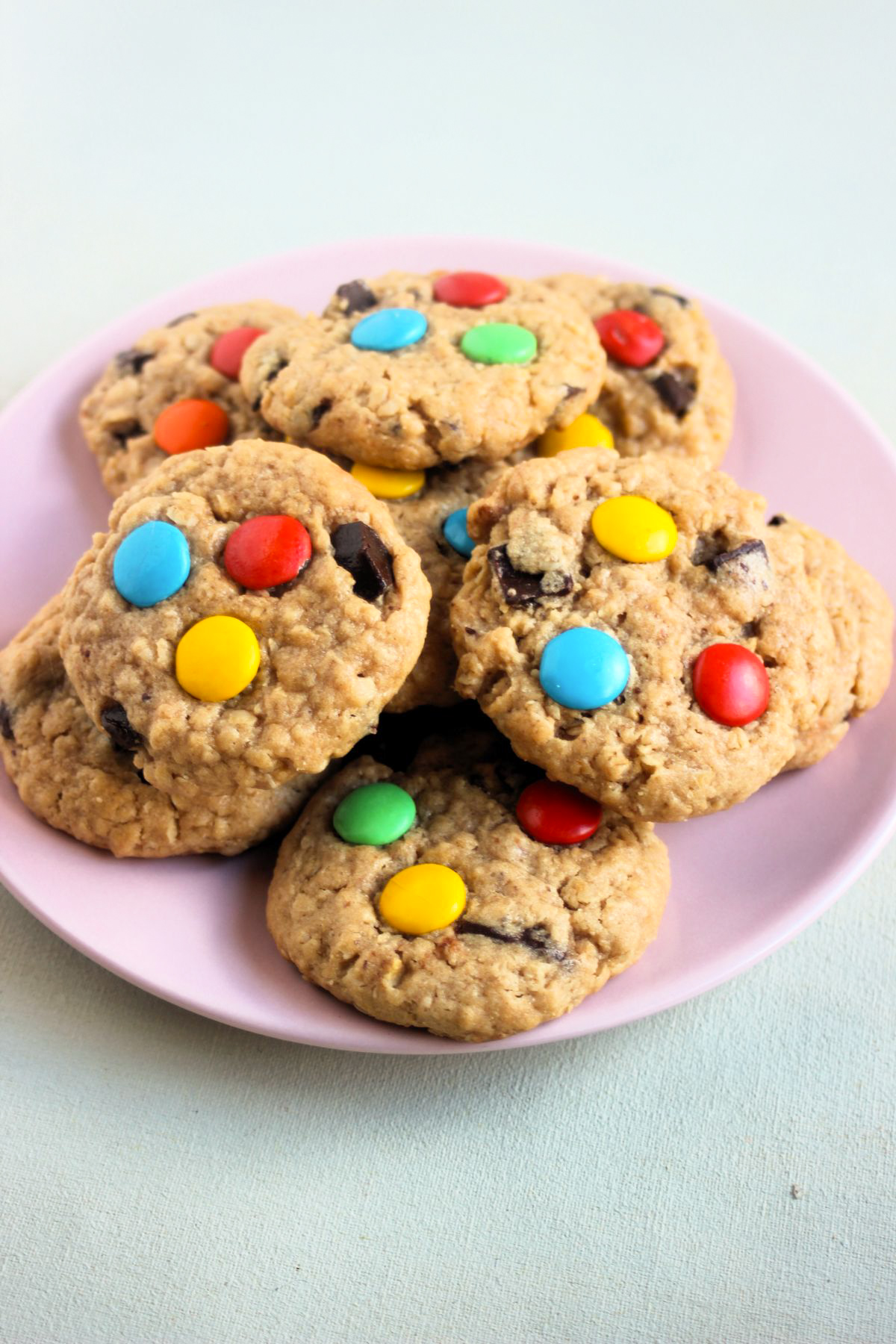 Many monster cookies on a pink plate.