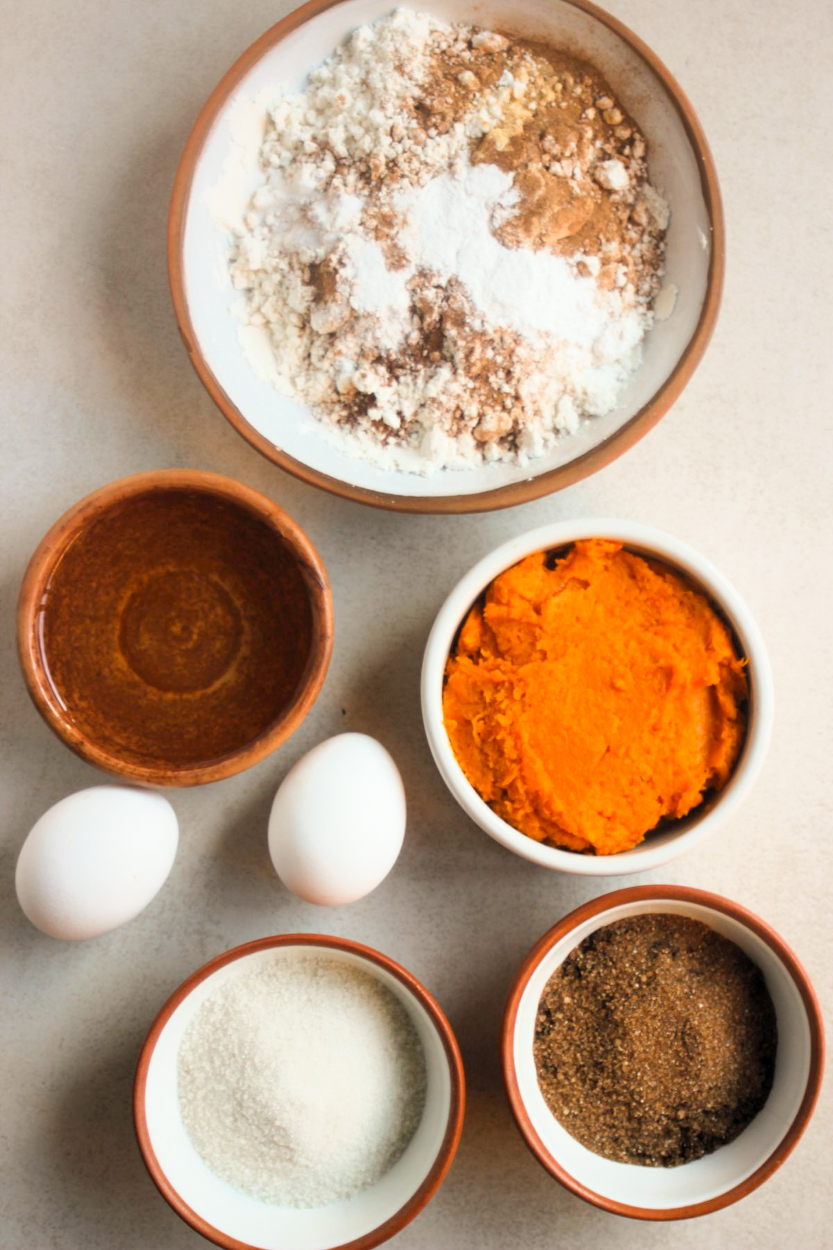 Top view of pumpkin cake ingredients on a white surface.