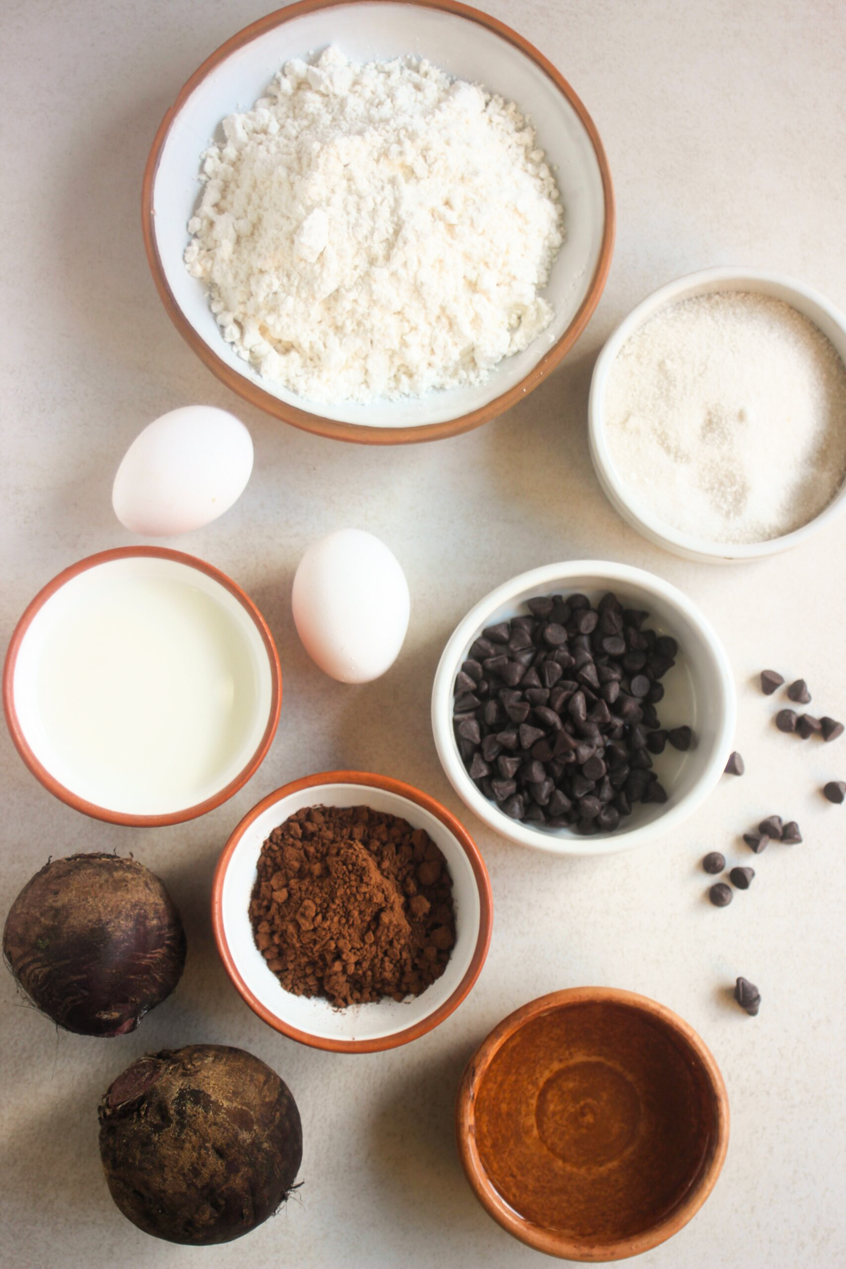 Top view of chocolate beet cake ingredients on a white surface.