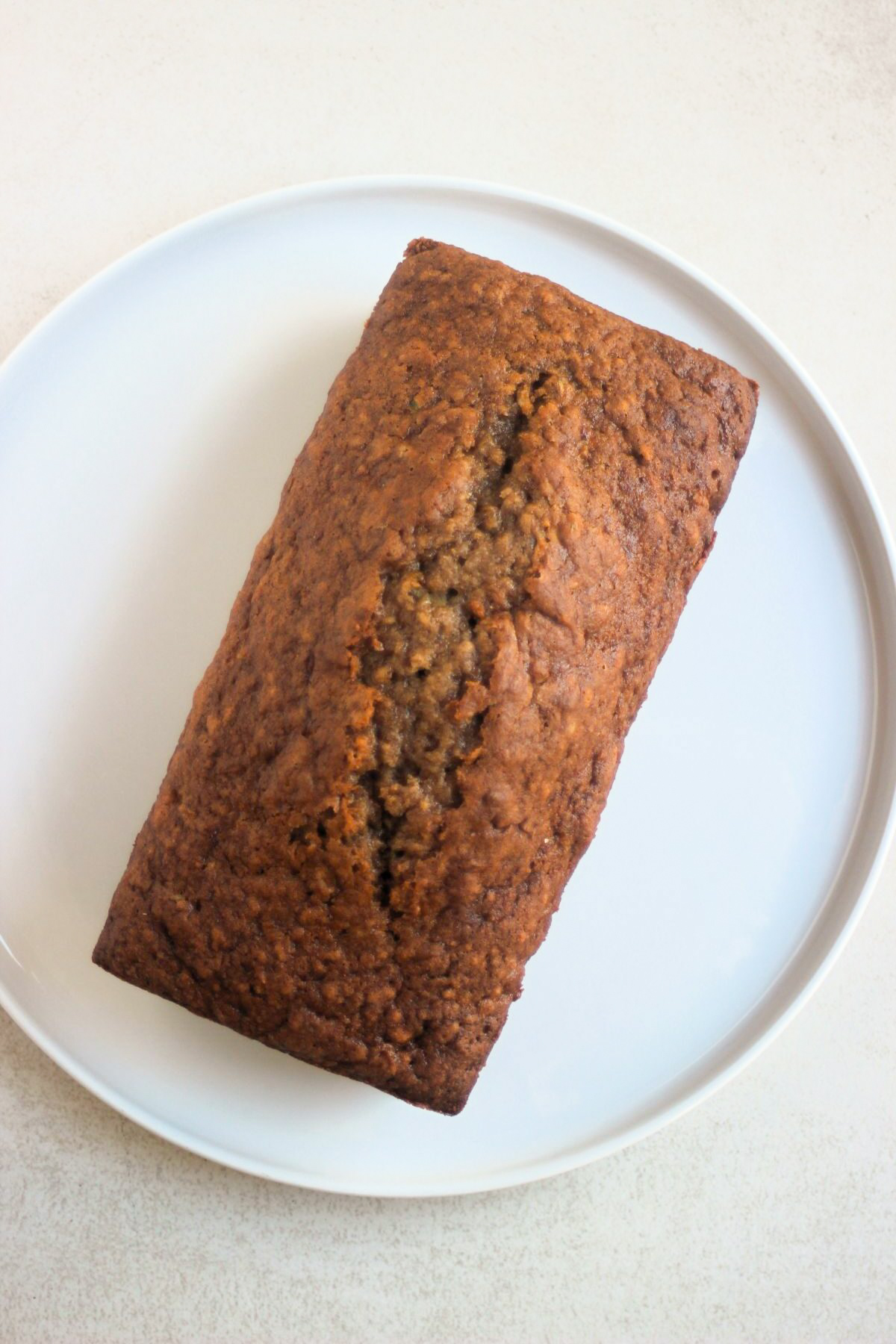 Top view of zucchini bread on a white plate.