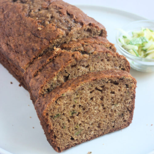 Front view of sliced zucchini bread on a white plate.