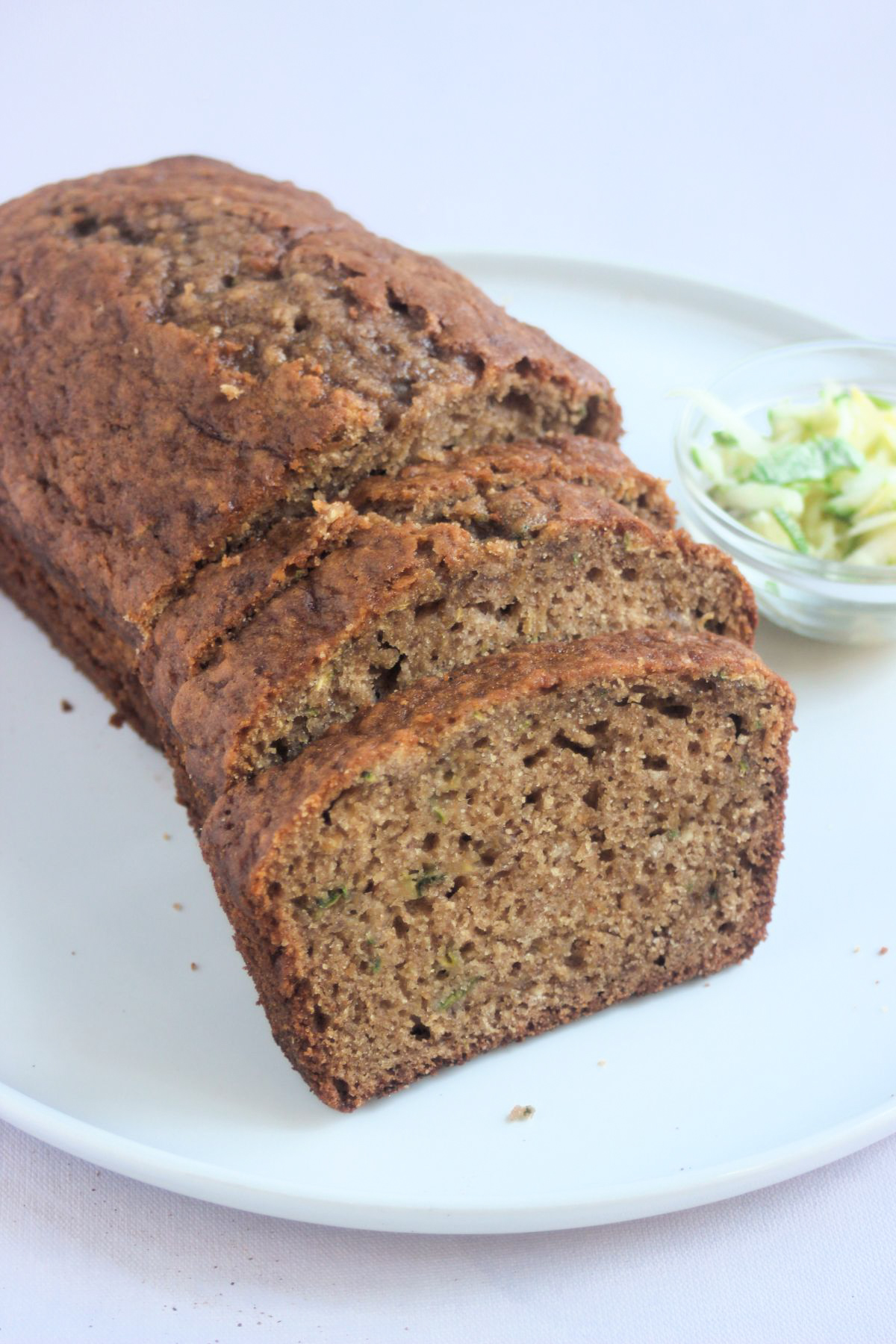 Front view of sliced zucchini bread on a white plate.