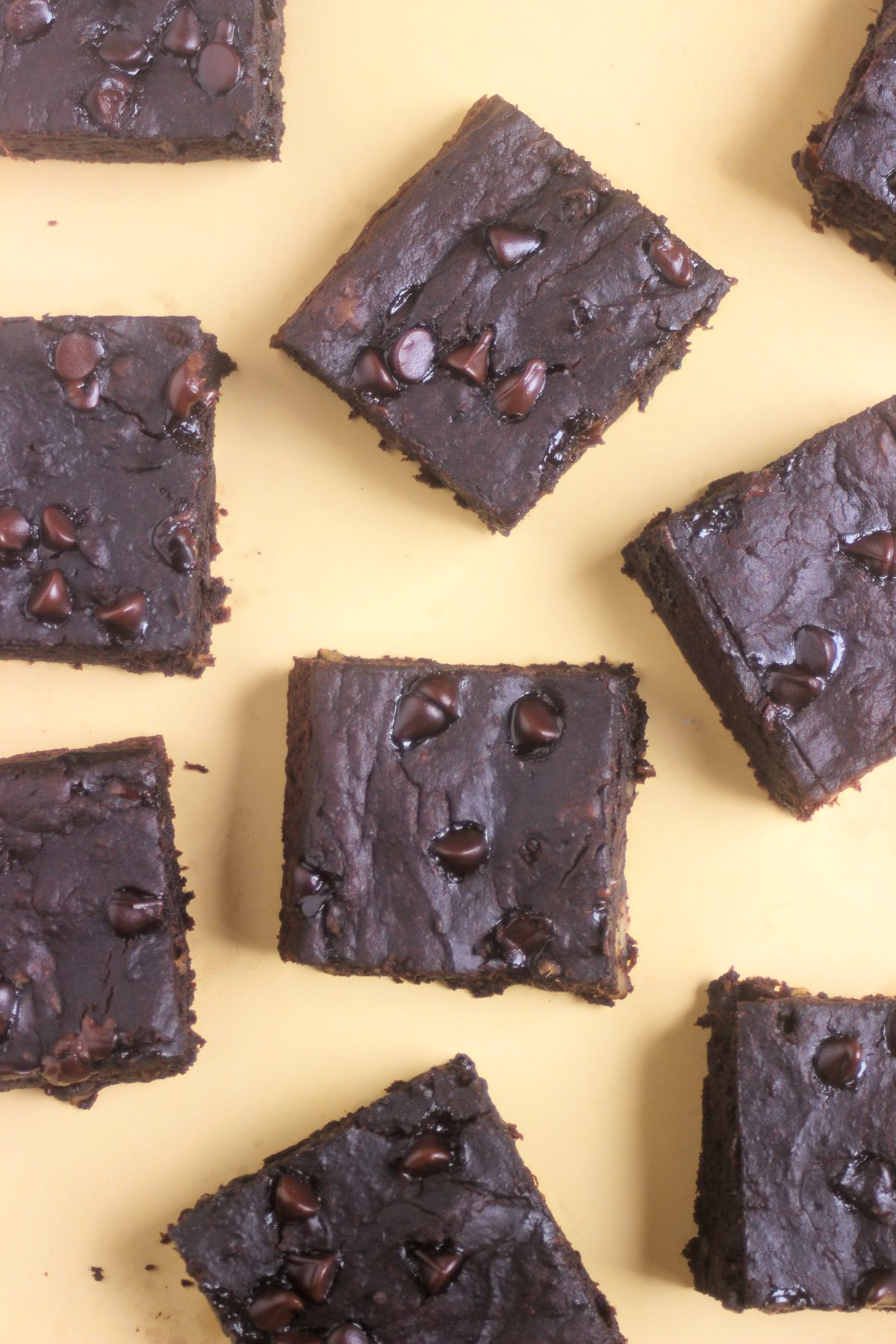 Top view of sweet potato brownies on a yellow surface.